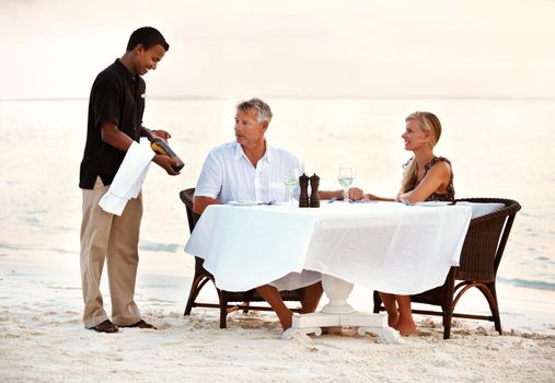 Shot of a mature couple enjoying a romantic dinner on the beach.