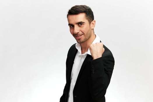 portrait of a successful business man in a black suit clenching his fist business professionals white studio background, copy space. High quality photo