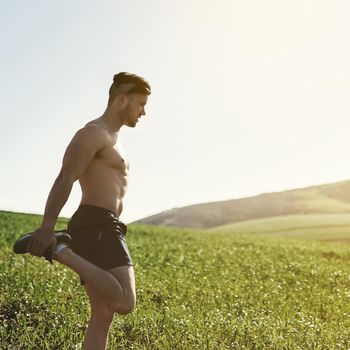 Cropped shot of a young man stretching outdoors before a run.