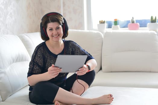 woman working on tablet and a wearing headphones