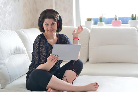 woman working on tablet and a wearing headphones