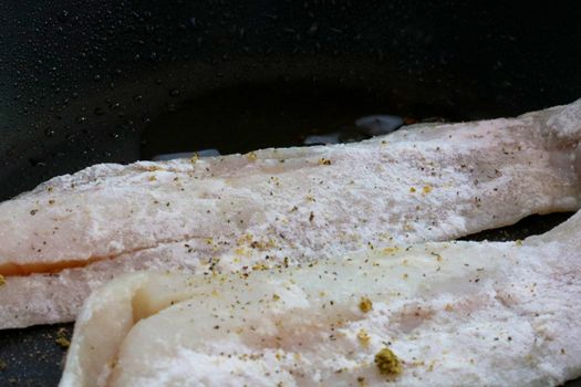 Cooking fish in a frying pan. Healthy delicious food