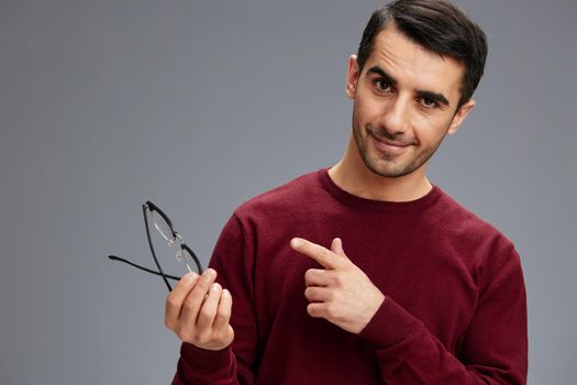 successful man eyeglasses in hand in a sweater posing emotions. High quality photo