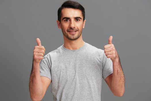 portrait man fun gray t-shirt hand gesture isolated background. High quality photo