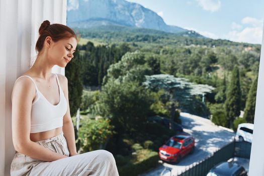 pretty woman sitting on the balcony admiring the nature of the mountain. High quality photo