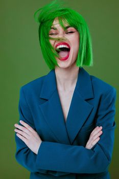 Portrait of a charming lady wearing a green wig blue jacket posing green background unaltered. High quality photo