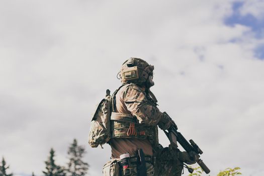 War concept. A bearded soldier in a special forces uniform fighting an enemy in a forest area. Selective focus. High-quality photo