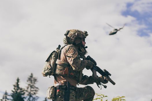 War concept. A bearded soldier in a special forces uniform fighting an enemy in a forest area. Selective focus. High-quality photo