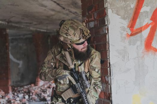 A bearded soldier in the uniform of special forces in dangerous military action in a dangerous enemy area. Selective focus. High-quality photo