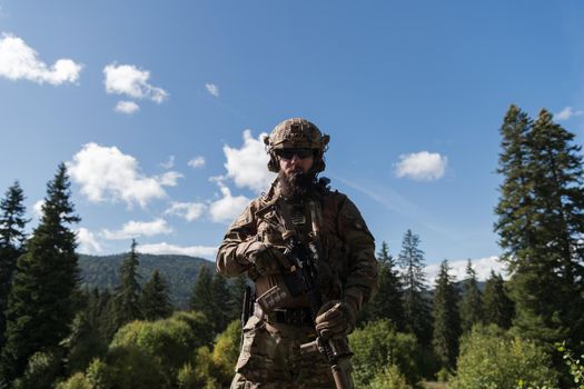 War concept. A bearded soldier in a special forces uniform fighting an enemy in a forest area. Selective focus. High-quality photo