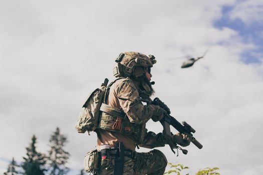 War concept. A bearded soldier in a special forces uniform fighting an enemy in a forest area. Selective focus. High-quality photo