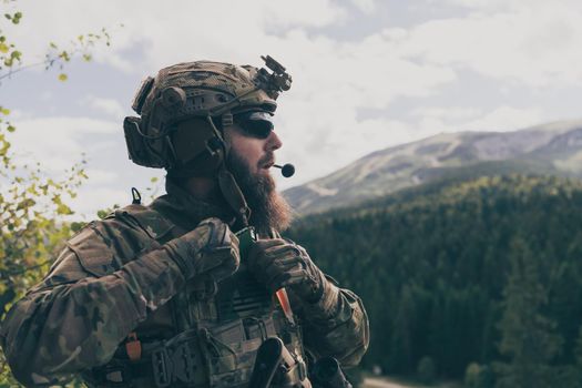 War concept. A bearded soldier in a special forces uniform fighting an enemy in a forest area. Selective focus. High-quality photo