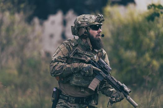 A bearded soldier in the uniform of special forces in dangerous military action in a dangerous enemy area. Selective focus. High-quality photo