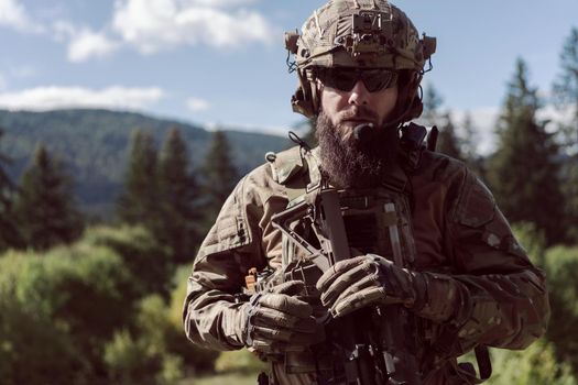 War concept. A bearded soldier in a special forces uniform fighting an enemy in a forest area. Selective focus. High-quality photo