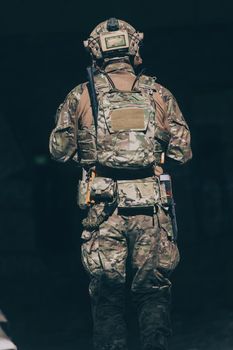 A bearded soldier in the uniform of special forces in dangerous military action in a dangerous enemy area. Selective focus. High-quality photo