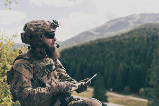 War concept. Bearded soldier in uniform of special forces in dangerous military action in dangerous enemy area studies attack tactics. Selective focus. High-quality photo