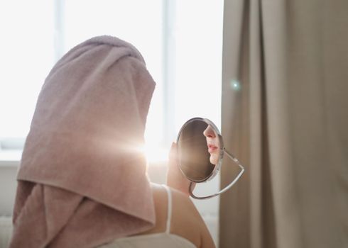 face of young beautiful healthy woman and reflection in the mirror at home.