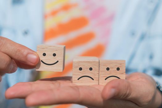 Smile face and cart icon on wood cube. Optimistic person or people feeling inside and service rating when shopping, satisfaction concept in business.