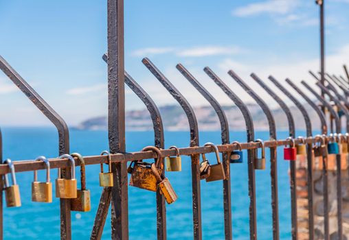 rusty padlock attached to a balustrade by the sea, a traditional way of showing love, relationship