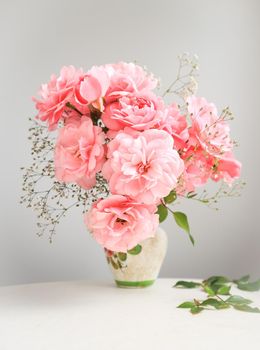 Bouquet of pink roses in a vase on a gray background