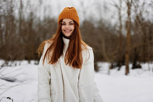 Happy young woman in winter clothes in a hat fun winter landscape Walk in the winter forest. High quality photo