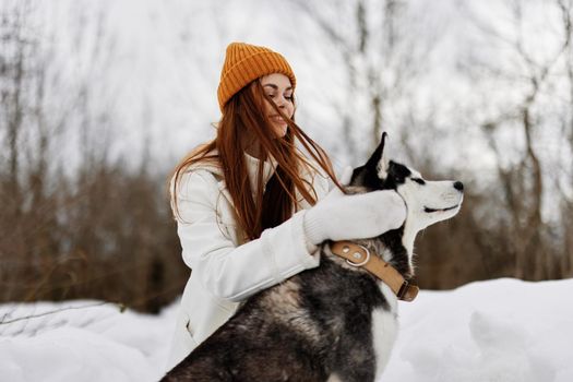 cheerful woman winter clothes walking the dog in the snow winter holidays. High quality photo