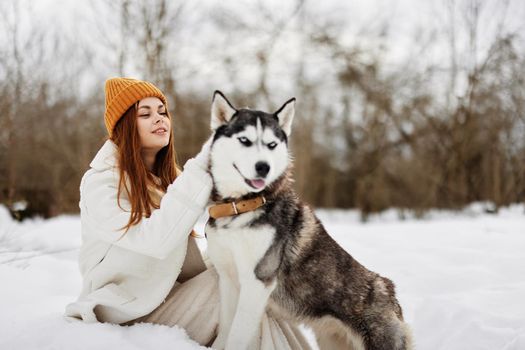 portrait of a woman in the snow playing with a dog outdoors friendship Lifestyle. High quality photo