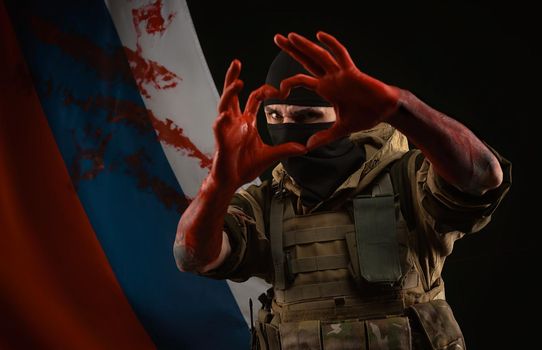 the men in military uniform and balaclava with bloody hands show a heart with their own hands against the background of the bloody flag of Russia