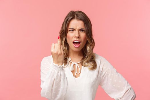 Close-up portrait of pissed-off bothered and fed up blond girlfriend arguing with boyfriend, showing him finger without ring as willing finally get married, standing upset pink background.