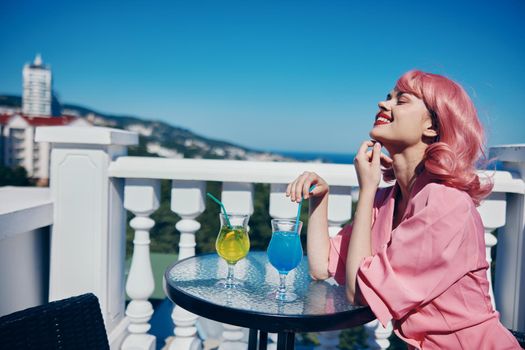 fashionable woman enjoying a colorful cocktail hotel terrace Happy female relaxing. High quality photo