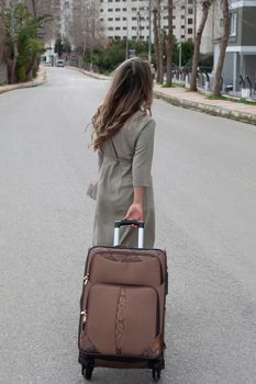 girl with brown suitcase is going on a road ready to move