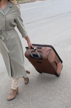 girl with brown suitcase is going on a road ready to move