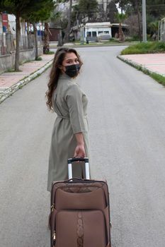 girl with brown suitcase is going on a road ready to move