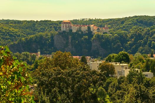 Beautiful autumn landscape with river, castle and blue sky with clouds and sun. Vranov nad Dyji (Vranov above Thaya) chateau, river Thaya, Czech Republic.