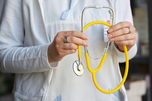 Female doctor holding a stethoscope. Concept for health and medicine. Hospital background.