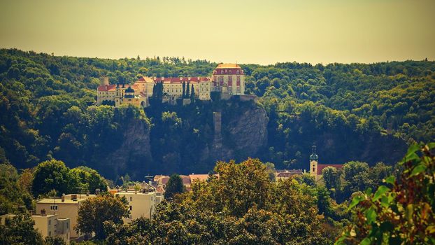 Beautiful autumn landscape with river, castle and blue sky with clouds and sun. Vranov nad Dyji (Vranov above Thaya) chateau, river Thaya, Czech Republic.