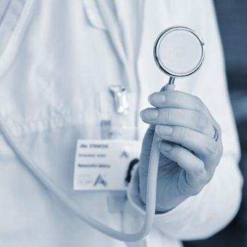 Female doctor holding a stethoscope. Concept for health and medicine. Hospital background.