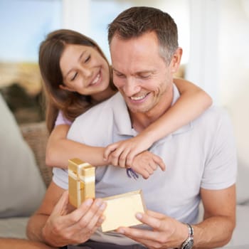 A young girl giving her dad a gift for fathers day.