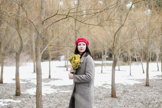 beautiful portrait of a young woman with mimosa flowers outdoors