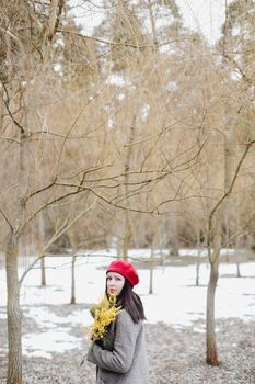 beautiful portrait of a young woman with mimosa flowers outdoors