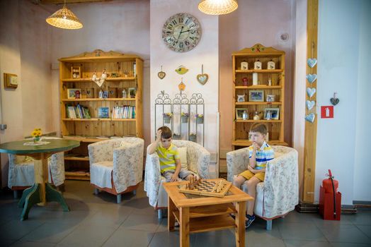 Vivid emotions during the game of chess. two young chess players inside hotel lobby. Tournament chess competition concept.