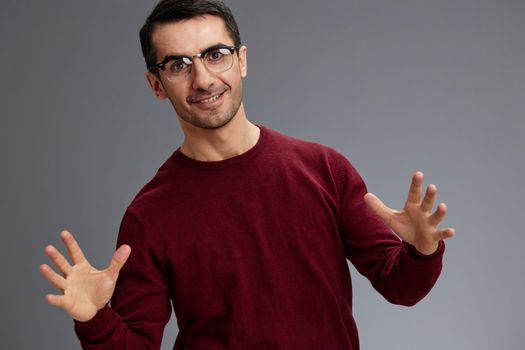 man wearing glasses smile posing gesture with hands red sweater isolated background. High quality photo