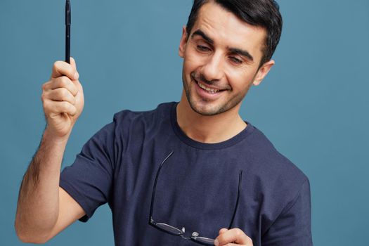 Cheerful man in blue t-shirts with glasses posing emotions isolated background. High quality photo