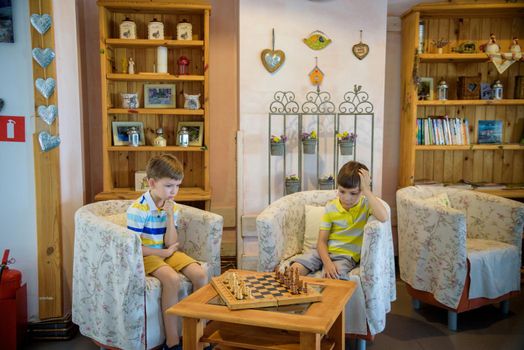 Vivid emotions during the game of chess. two young chess players inside hotel lobby. Tournament chess competition concept.