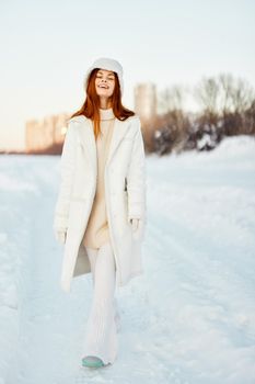 young woman in a white coat in a hat winter landscape walk Lifestyle. High quality photo