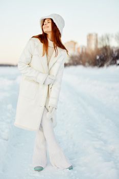 pretty woman in a white coat in a hat winter landscape walk Fresh air. High quality photo
