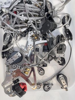 Close-up view of set of ship equipment, ropes for management of the sailboat of different color, pulleys and ropes, yachting sport, the signature to each rope, rollers, levers, carbines, clamps. High quality photo