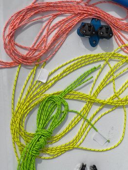 Close-up view of set of ship equipment, ropes for management of the sailboat of different color, yachting sport, the signature to each rope, rollers, carbines, clamps. High quality photo