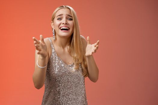 Lifestyle. Panicking upset miserable heartbroken blond girl crying raising hands begging not go broke-up boyfriend look sorrow distressed freak-out standing devastated red background during party.