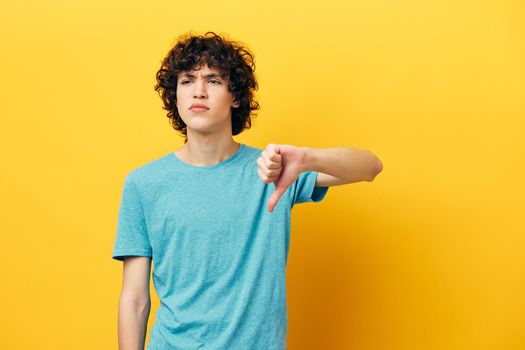 guy showing thumb down dissatisfaction yellow background. High quality photo